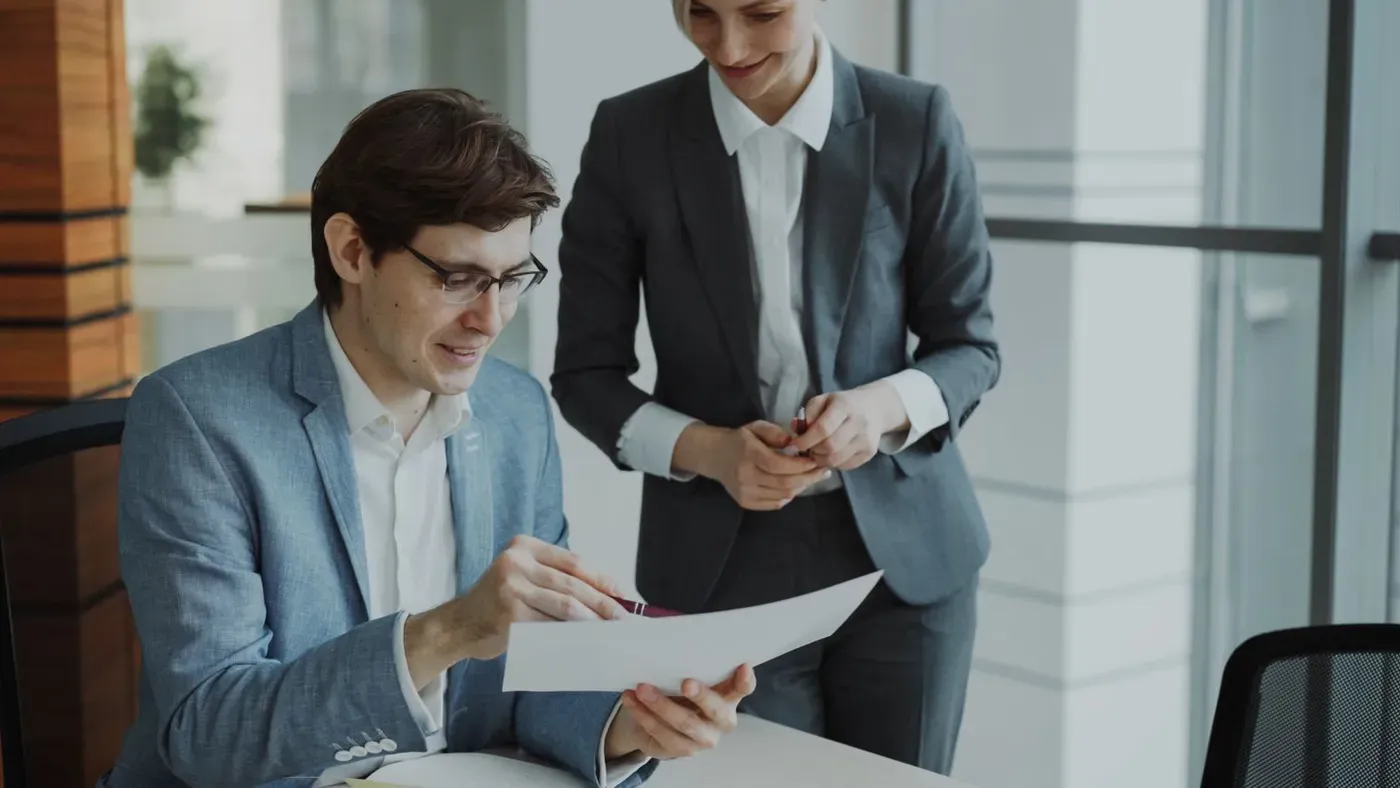 Dos profesionales revisando un documento en una oficina contemporánea